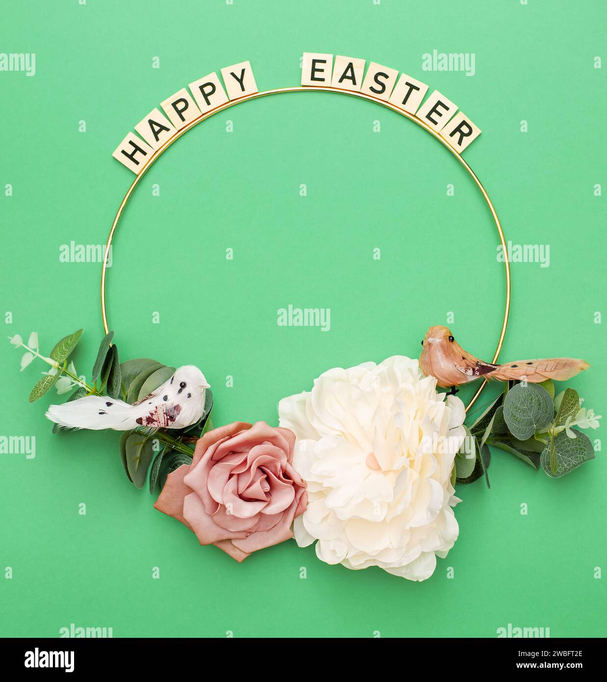 Happy Easter. Handmade Easter decor, Easter eggs and flowers on a green background. Easter wreath shape Stock Photo
