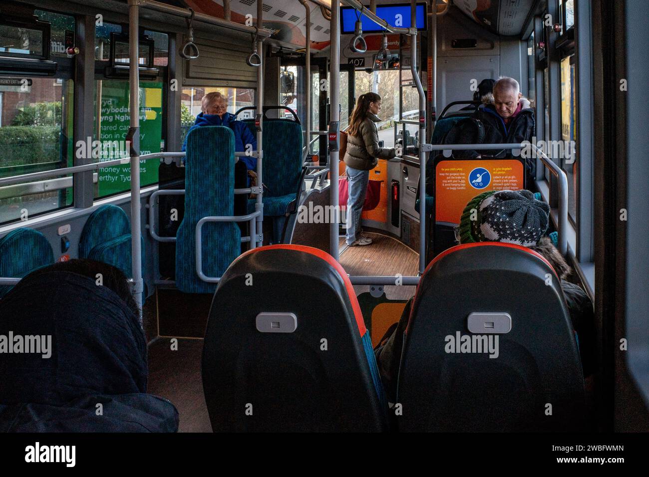 View from inside a Bus on a city route - Bus interior with passengers and someone buying a ticket. UK. Concept Transportation. Sustainable travel. Stock Photo
