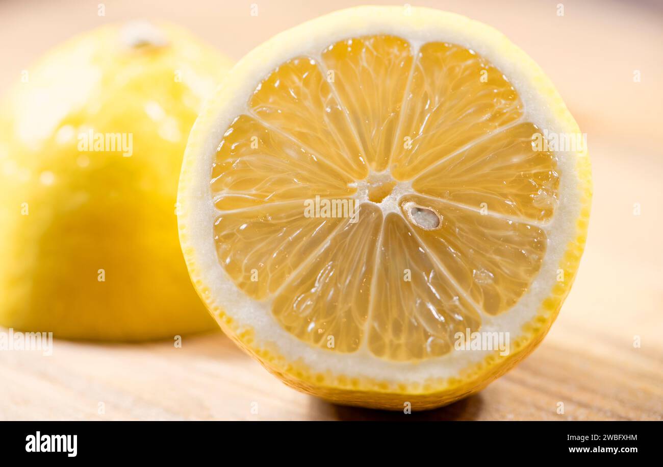 Half Cut Fresh Lemon with other half in background, bright and refreshing. Stock Photo
