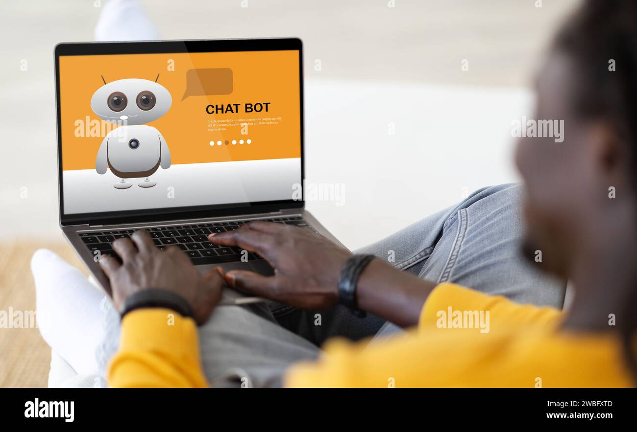 Over shoulder view african american man using chatbot on computer Stock Photo