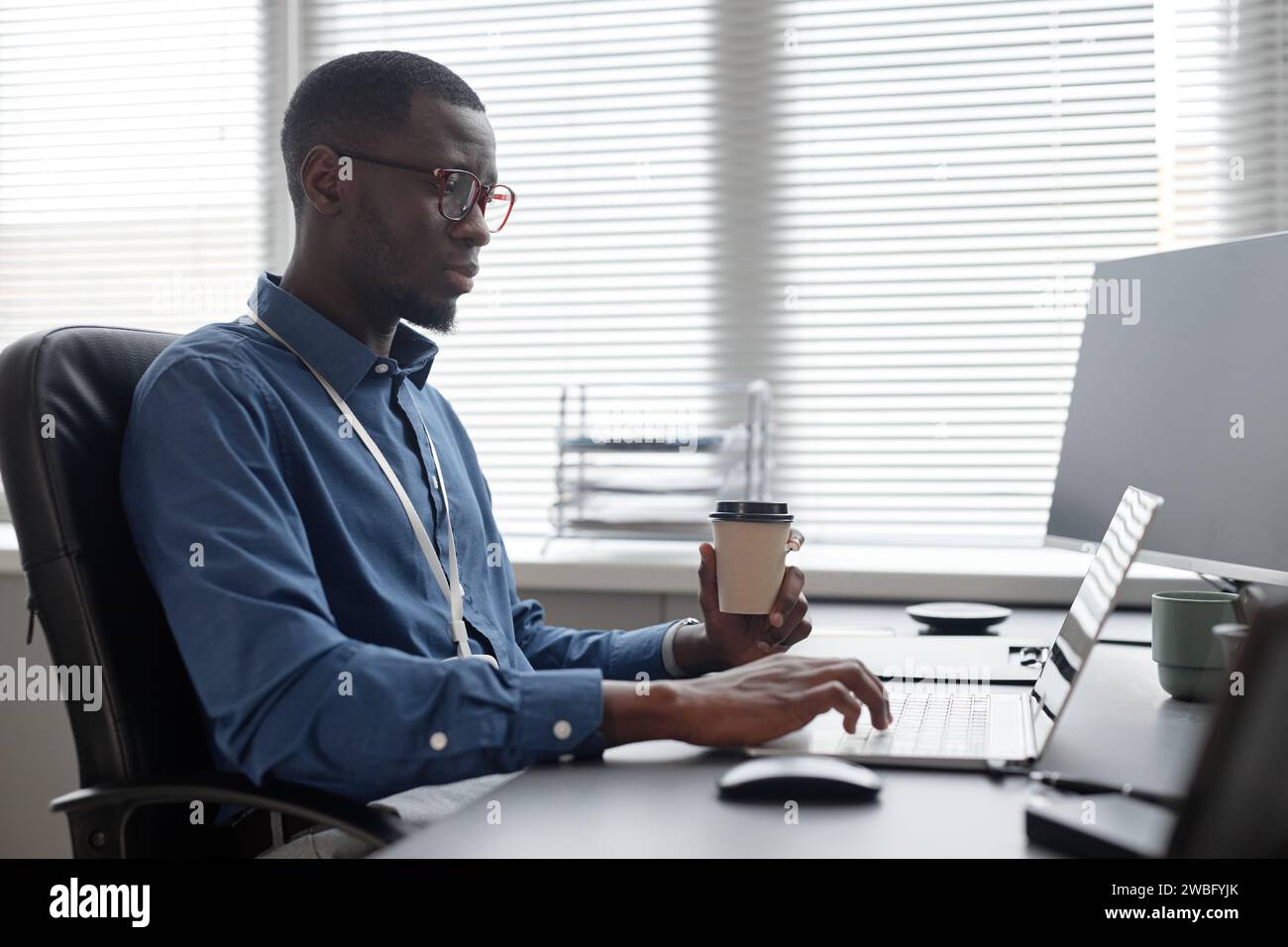 IT Professional Working and Drinking Coffee Stock Photo