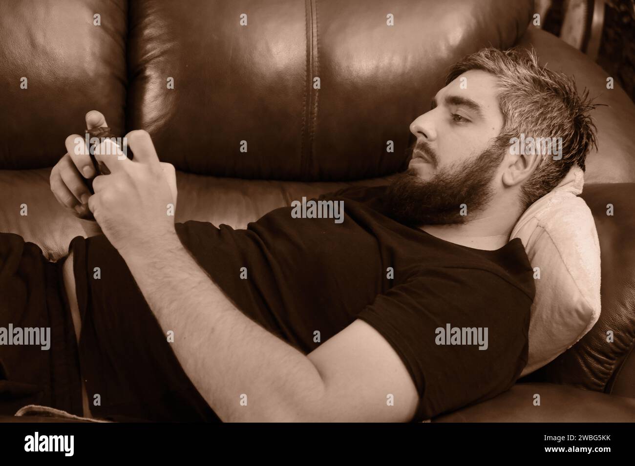 Happy guy using smartphone, enjoying leisure at home Stock Photo
