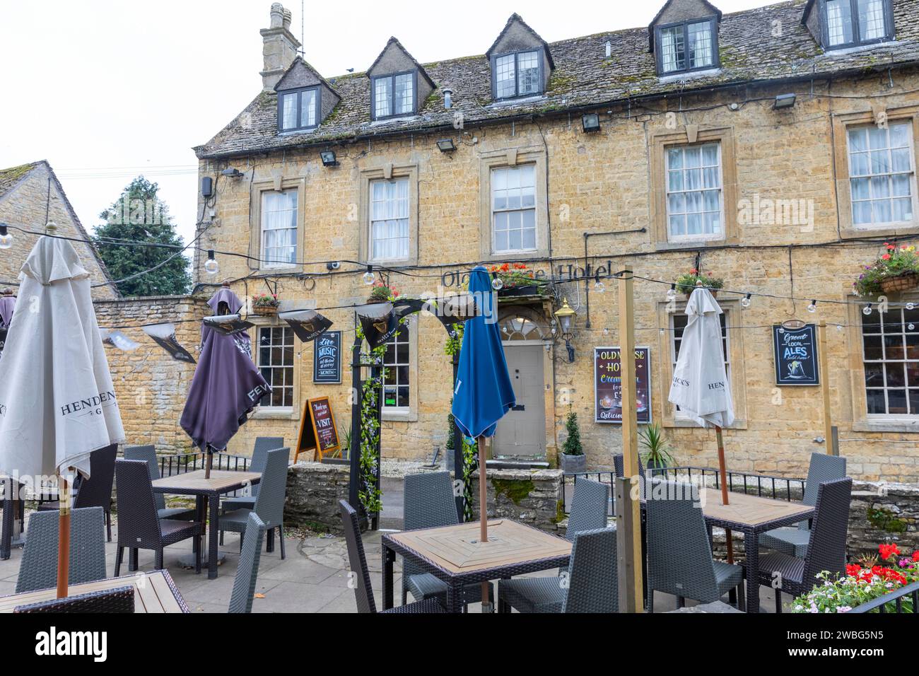 Bourton on the Water, Old Manse hotel pub with outside tables and parasols in this cotswold village, Gloucestershire,England,UK,2023 Stock Photo