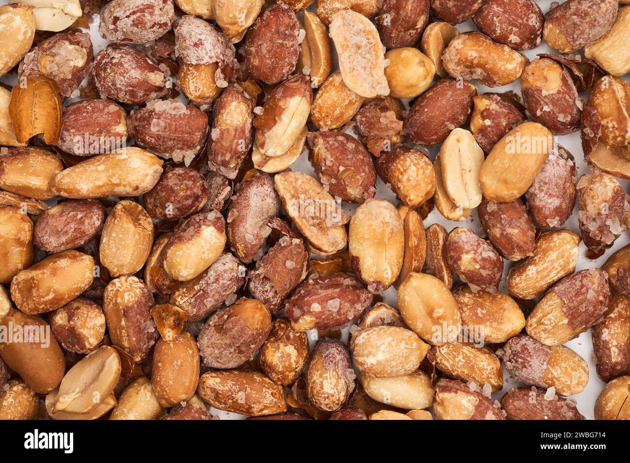 Oven baked salted peanuts in red skin, closeup studio shot Stock Photo