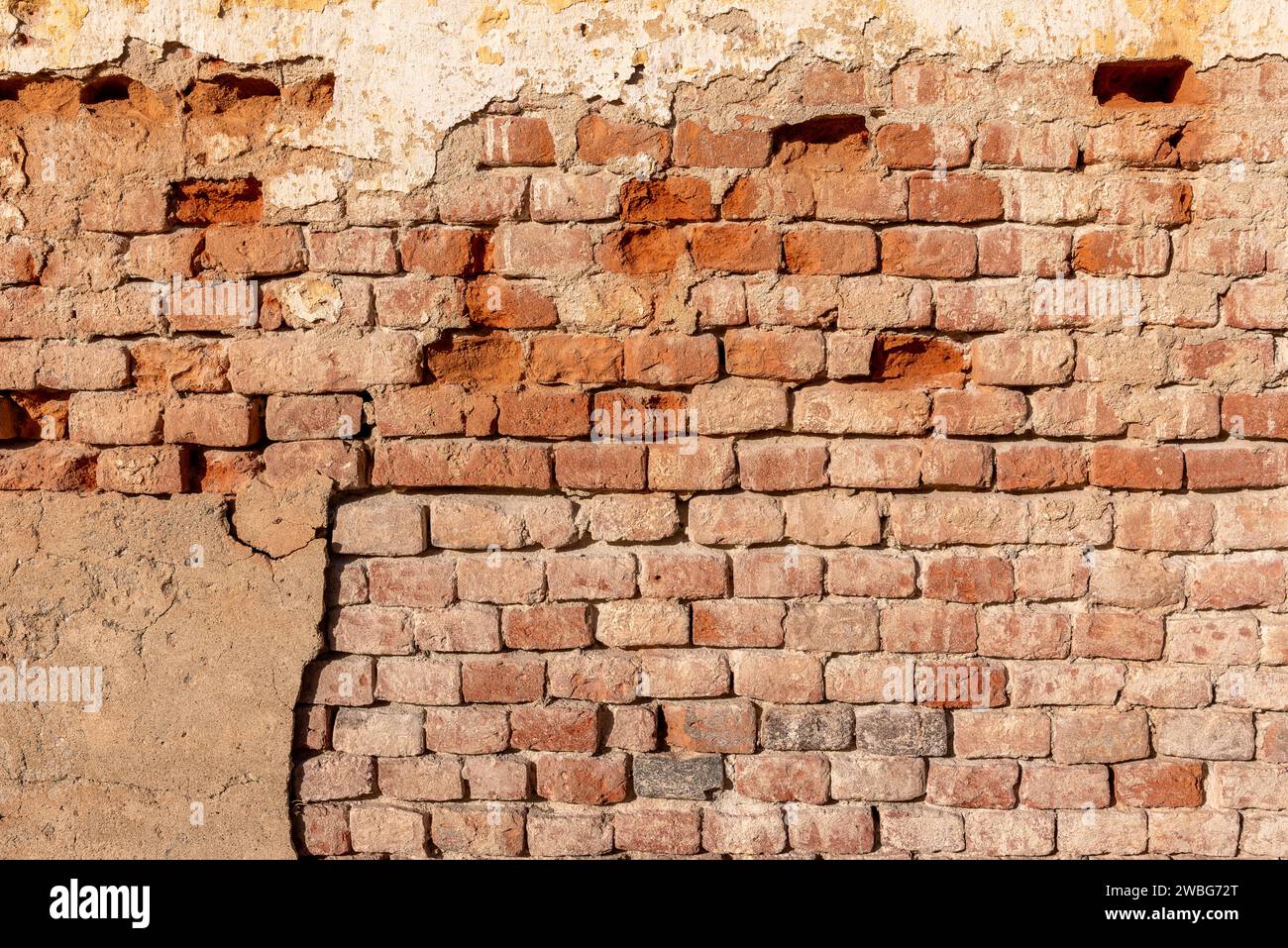 Old wall texture with plaster and peeling background with exposed brick. Ideal for background with space for copies Stock Photo