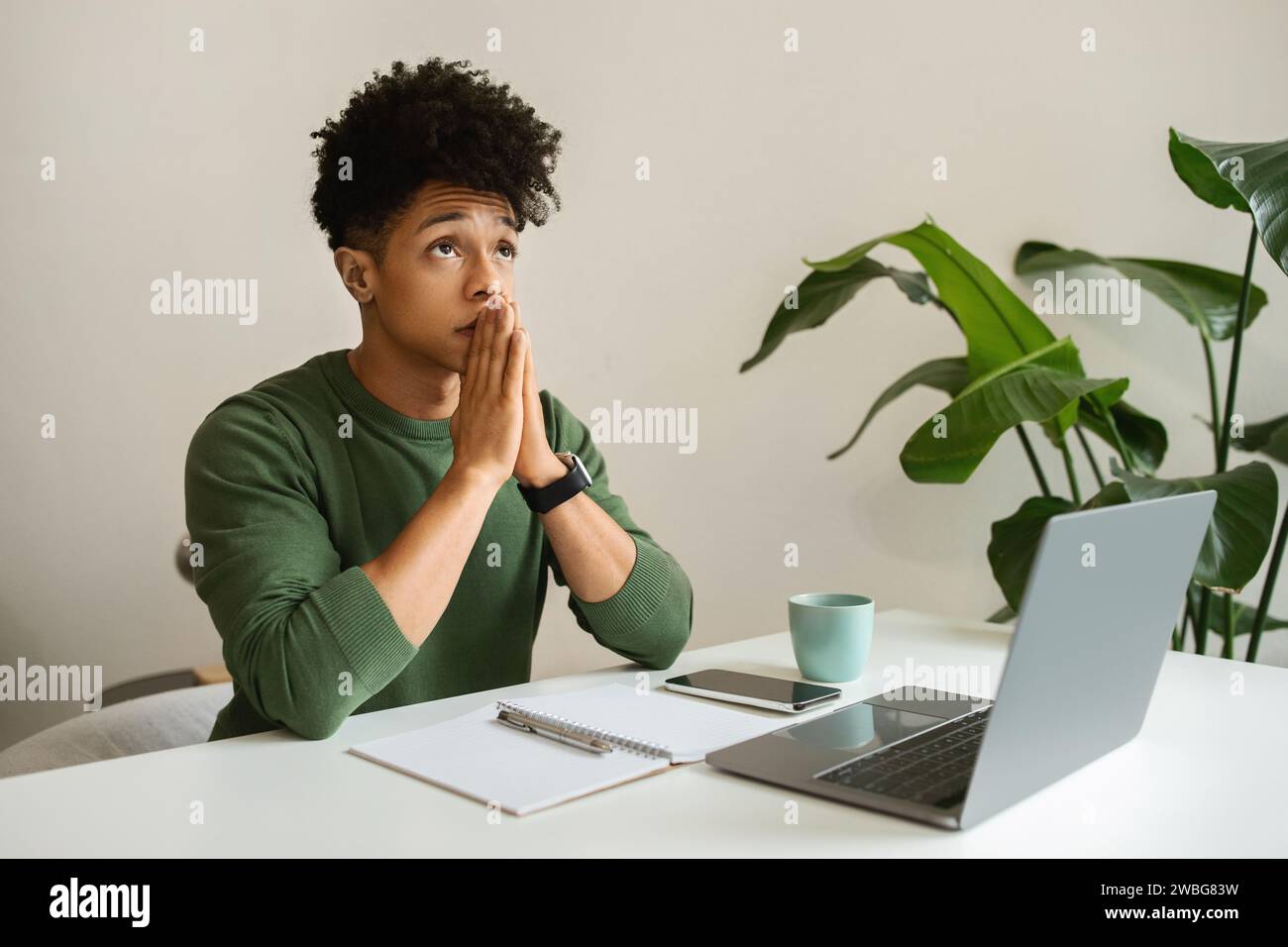 Pensive young black guy freelancer working from cozy cafe Stock Photo
