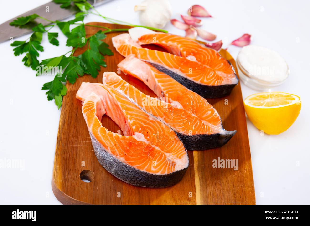 Raw salmon steaks on cutting board, over white background Stock Photo ...