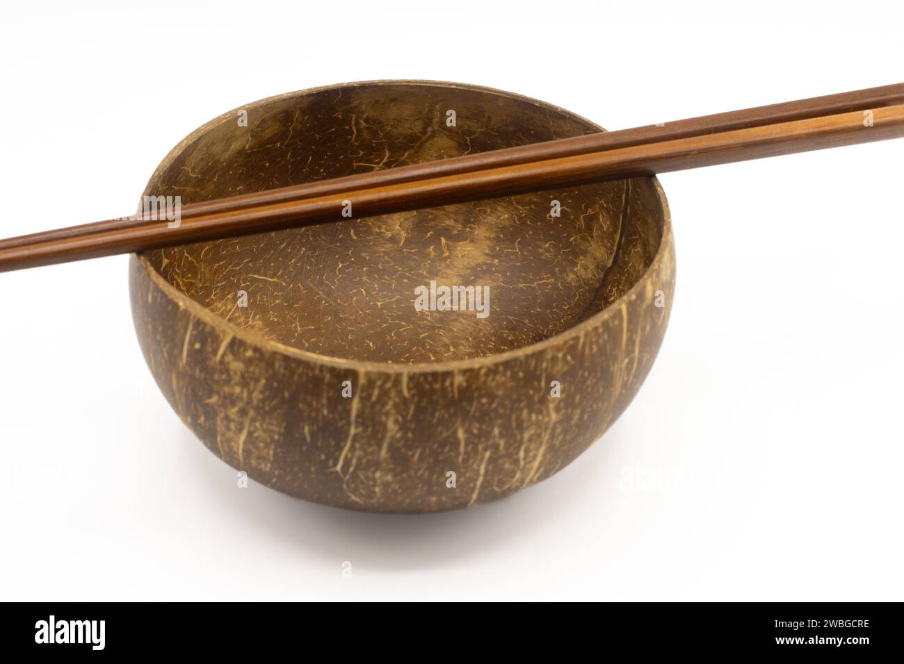 Empty coconut bowl and chopsticks isolated on white background Stock Photo