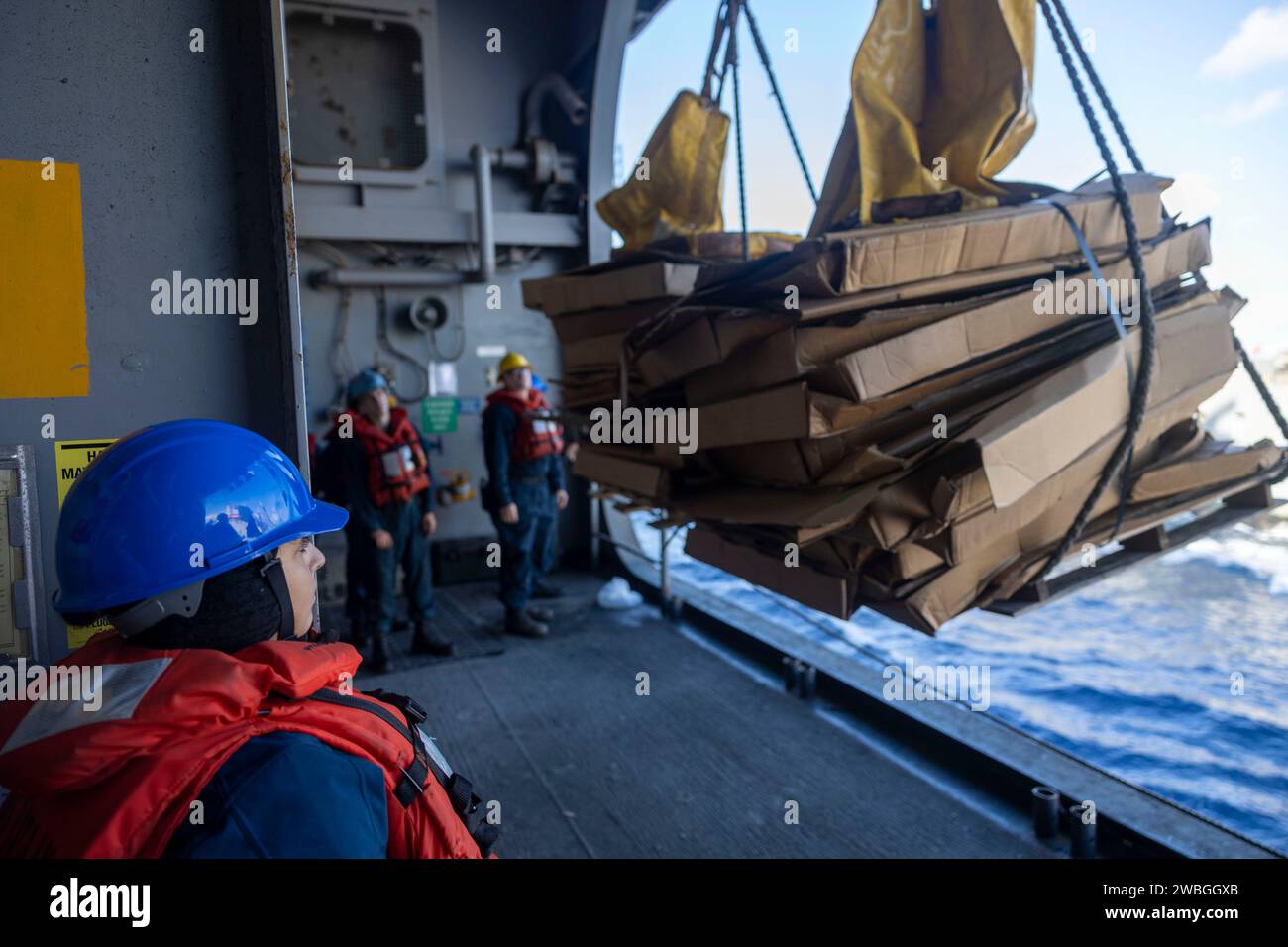 231229-N-OM737-1024  MEDITERRANEAN SEA (Dec. 29, 2023) Deck Department Sailors assigned to Wasp-class amphibious assault ship USS Bataan (LHD 5) offload pallets during a replenishment-at-sea with the Henry J. Kaiser-class replenishment oiler USNS Laramie (T-AO 203), Dec. 29. Bataan is on a scheduled deployment in the U.S. Naval Forces Europe area of operations, employed by U.S. Sixth Fleet to defend U.S. allied and partner interests. (U.S. Navy photo by Mass Communication Specialist 2nd Class Bradley Rickard) Stock Photo