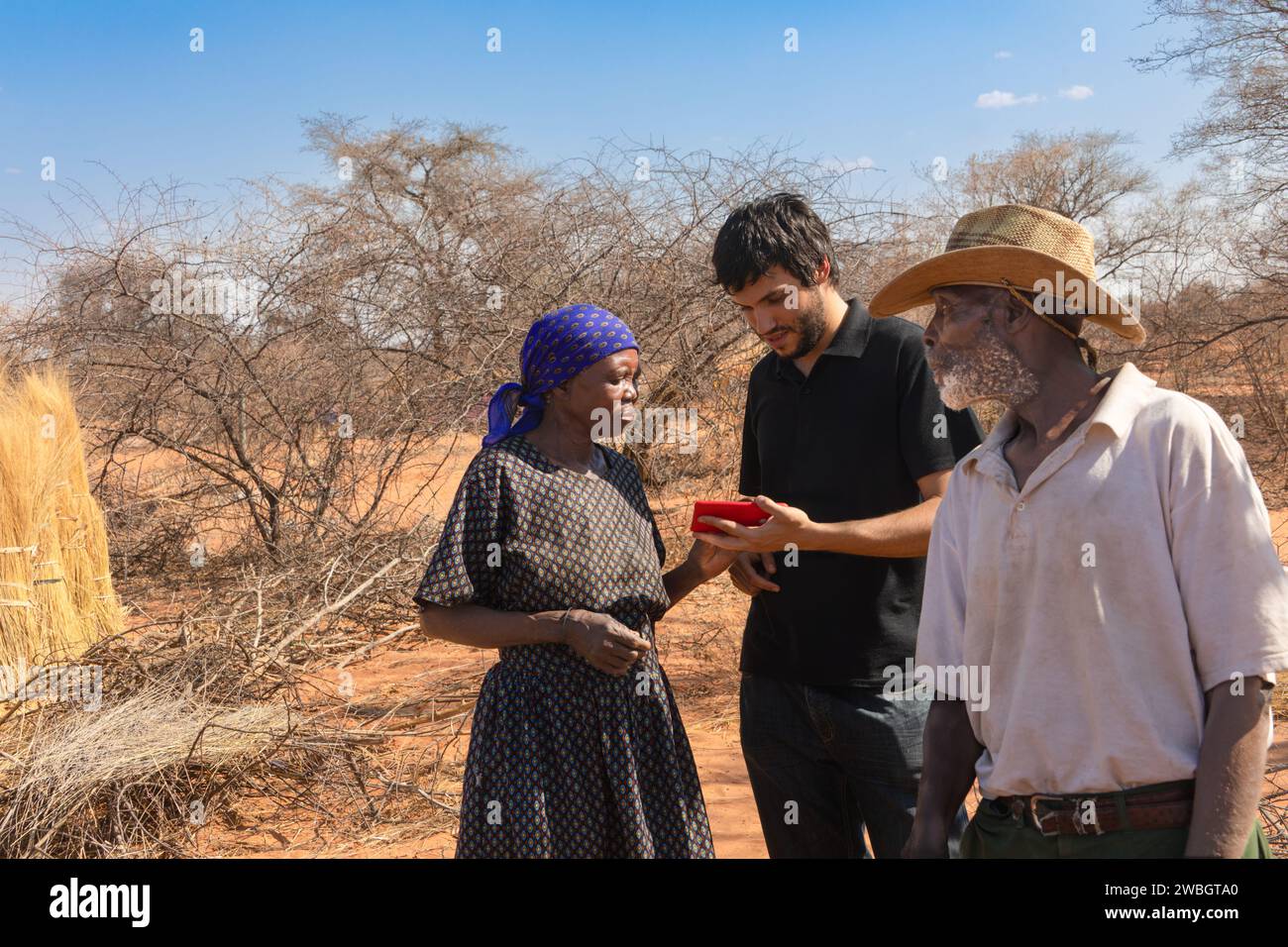 volunteer helping african villagers to use wireless technology to improve their small business Stock Photo