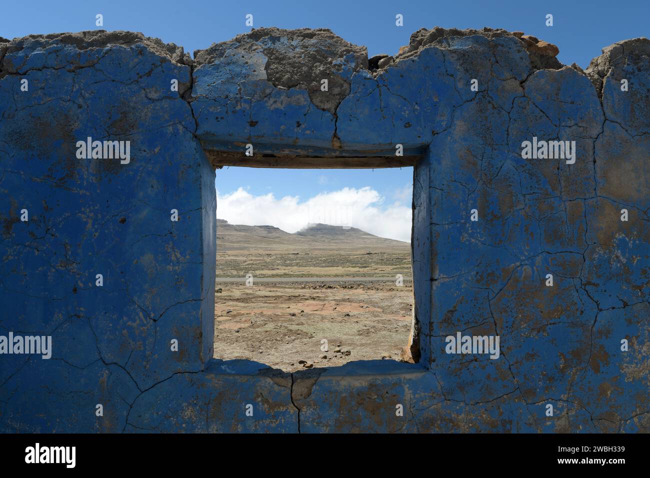 House in ruins, landscape view, window in wall of forsaken home, Kingdom of Lesotho, abandoned African homestead, hardship in Africa, poverty Stock Photo