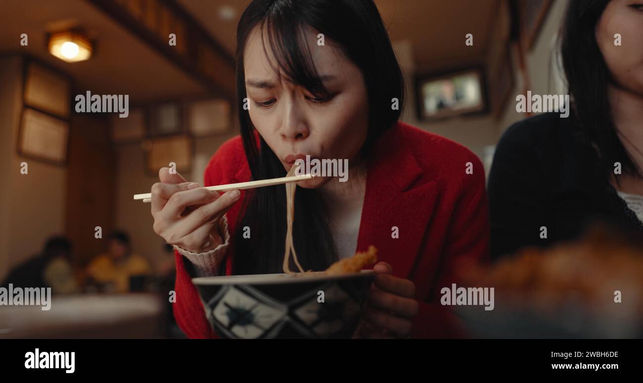Woman, restaurant and eating ramen noodles for nutrition, gourmet dining or meal with friends. Hungry lady, chopsticks or spaghetti for lunch, dinner Stock Photo
