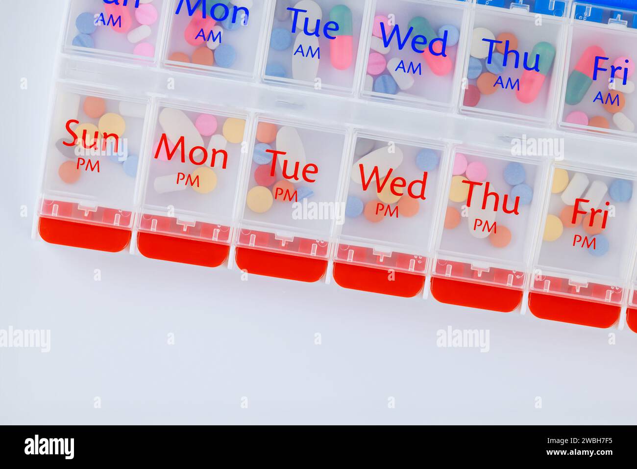 Organizer daily pill dispenser box is shown on white background with medication capsules inside