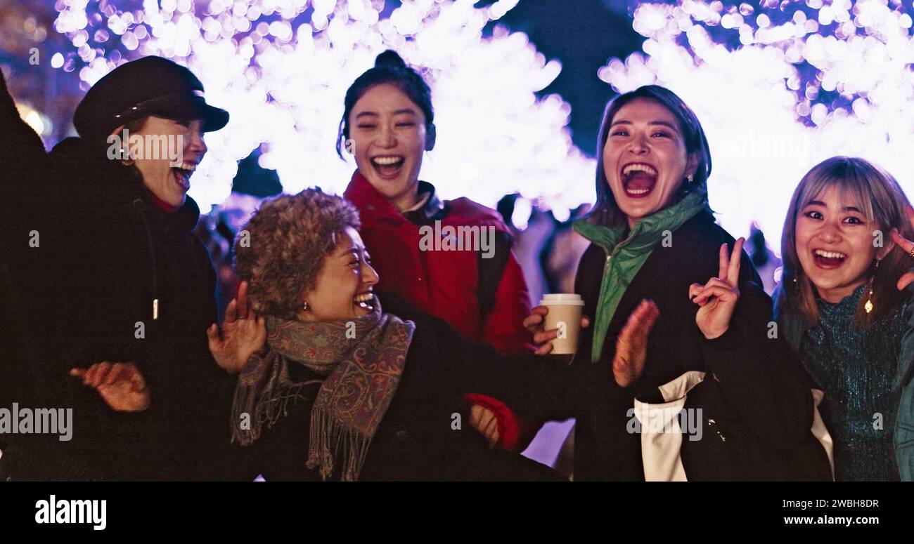 Women, city or happy people in festival, party or night event on holiday vacation on New Years. Japanese, dancing or group of friends laughing Stock Photo