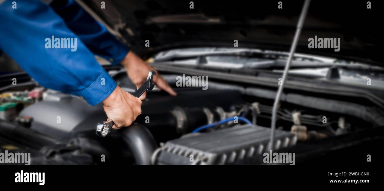 Car mechanic working on car engine, car maintenance concept Stock Photo