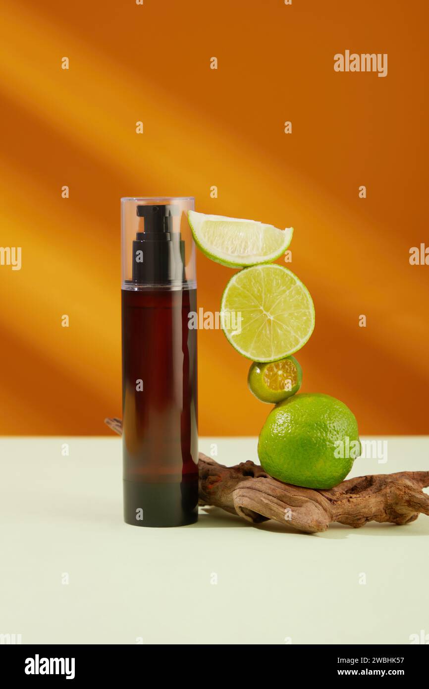 Pump bottle dispenser without label decorated with limes and kumquats over light background. Limes and kumquats are high in vitamin C, antioxidants, a Stock Photo