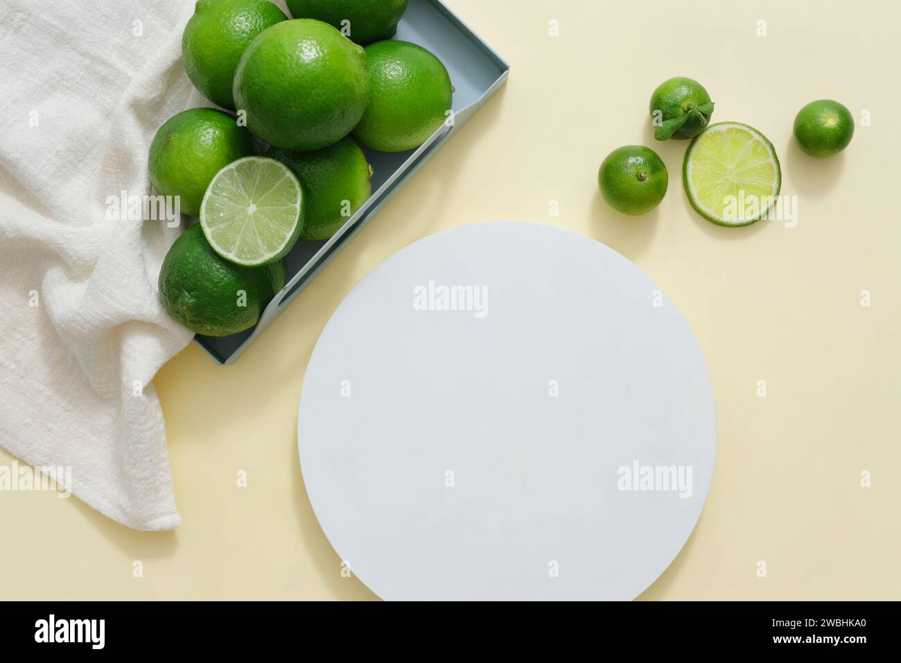 Empty podium in white color displayed with a tray of white towel with kumquat and lime. Vacant space to display natural beauty product extracted from Stock Photo