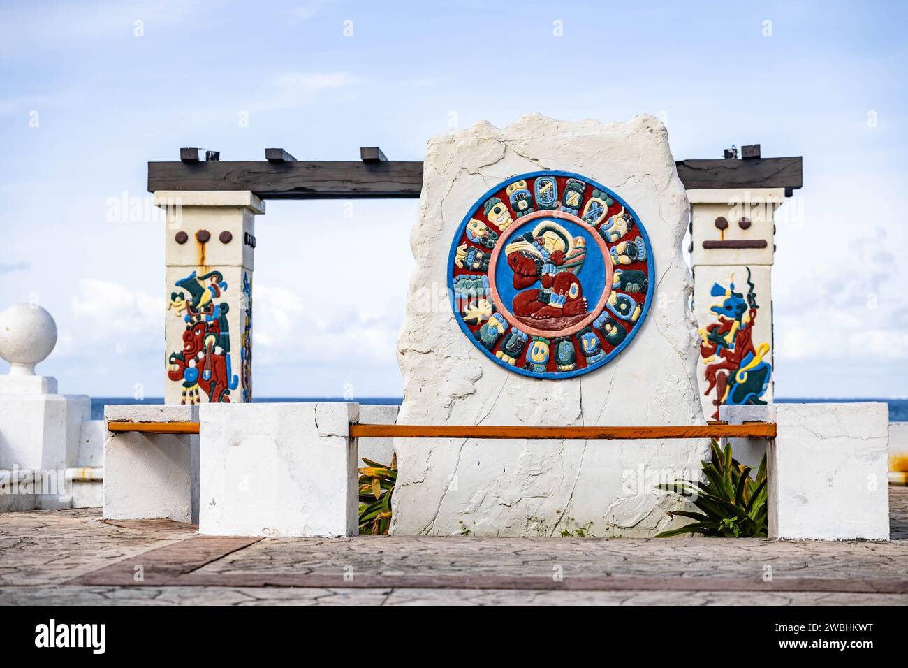 A concrete wall with two stone pillars on either side and a vibrant painting displayed between them Stock Photo