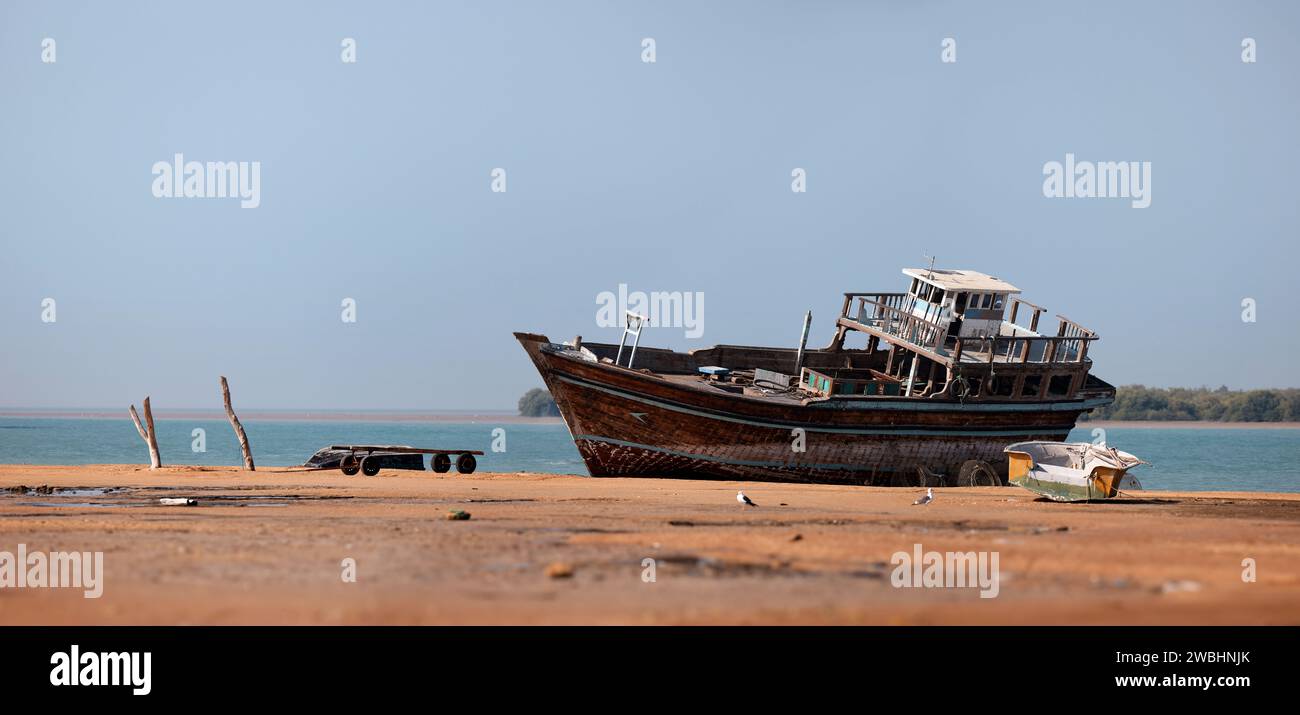 Traditional Dhow old wooden boat in the harbor of Iranian Qeshm Island. Tradition Lenj Fishing Boat in Qeshm Island in Southern Iran. Old wooden Stock Photo