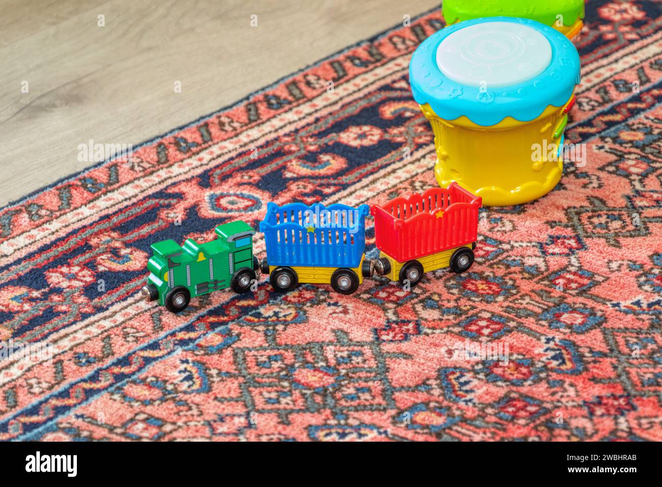 wooden children toys, train on the carpet, in the children room Stock Photo