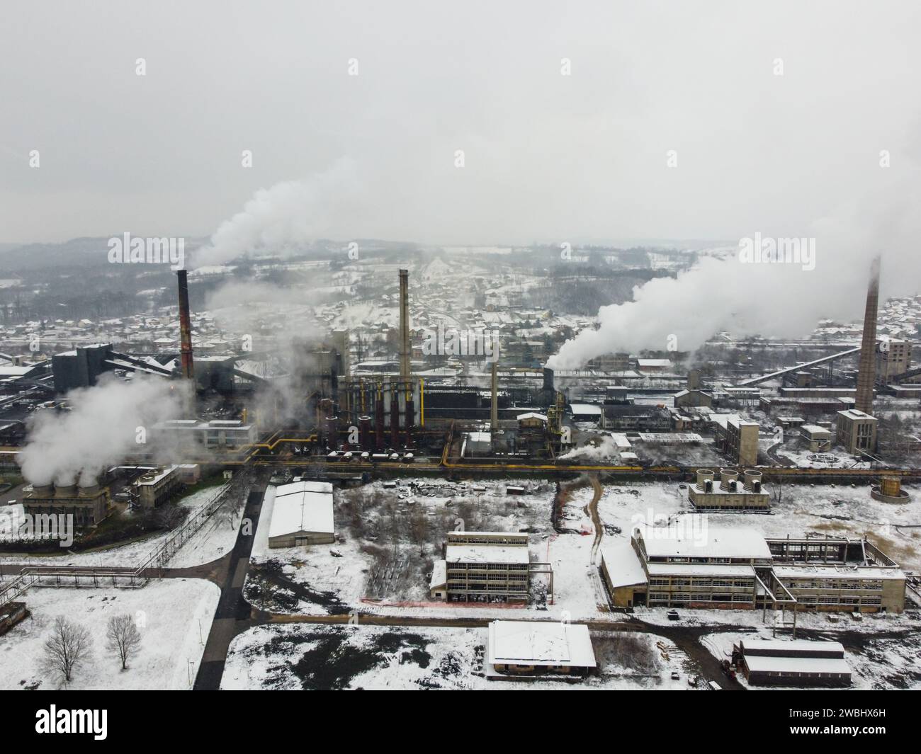 Factory chimneys blowing pollution in environment. Aerial drone view of industry complex. Industrial air pollution from smokestacks. Stock Photo