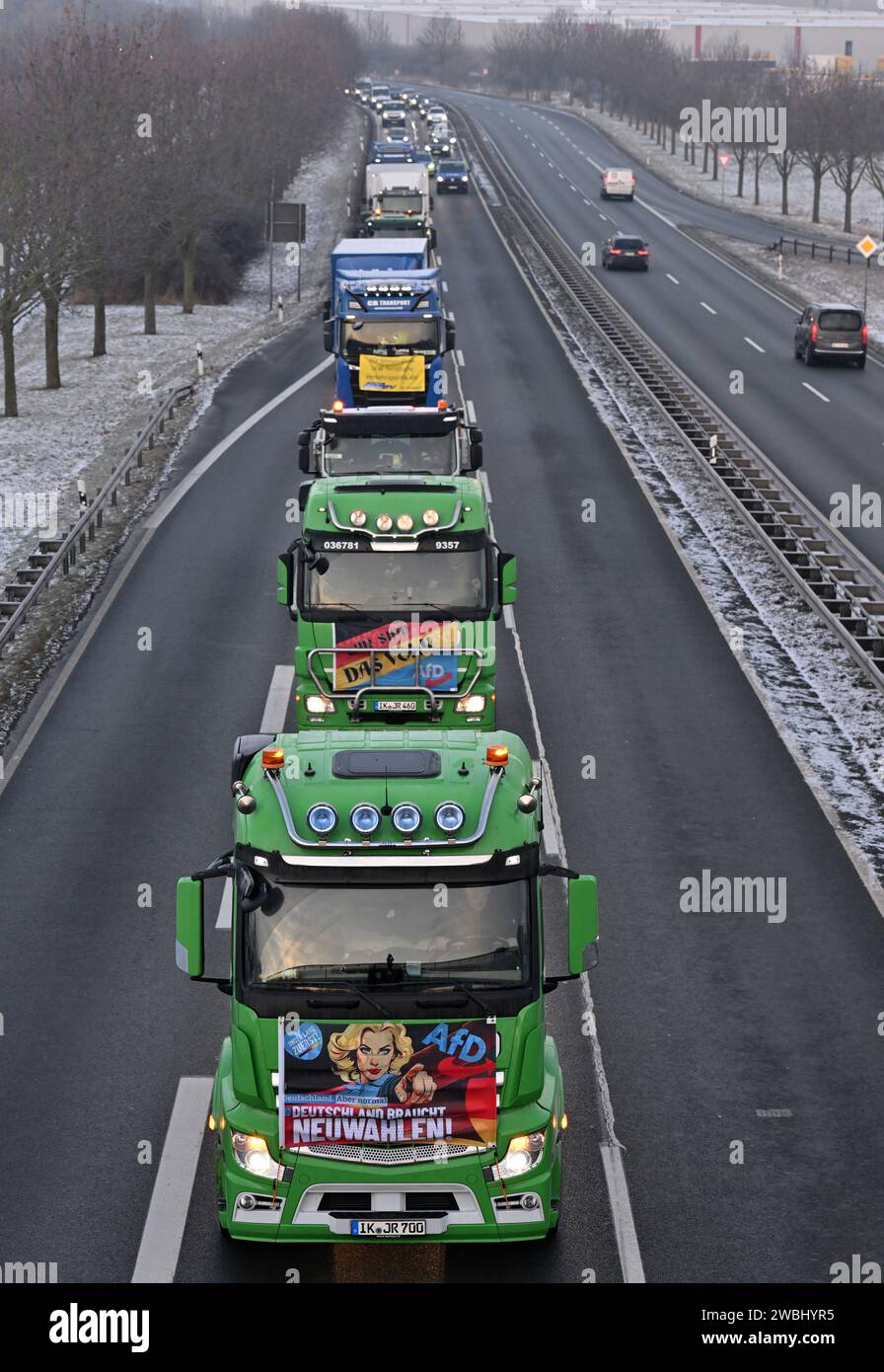 Vieselbach, Germany. 11th Jan, 2024. Trucks with banners drive in convoy along the B7 federal highway near Vieselbach. In addition to the protesting farmers, the state transport industry has also started a convoy. The hauliers wanted to protest against the double burden of the truck toll and CO2 levy. Around 150 vehicles took part in the protest. The convoy, which was around five kilometers long, rolled from Erfurt via Weimar to Jena. Credit: Martin Schutt/dpa/Alamy Live News Stock Photo