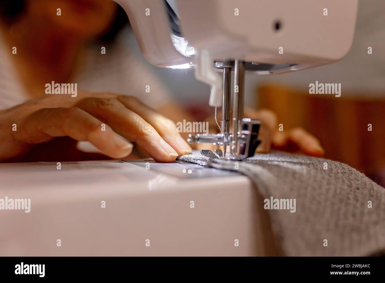Woman, sewing small pillows on a sewing machine at home Stock Photo
