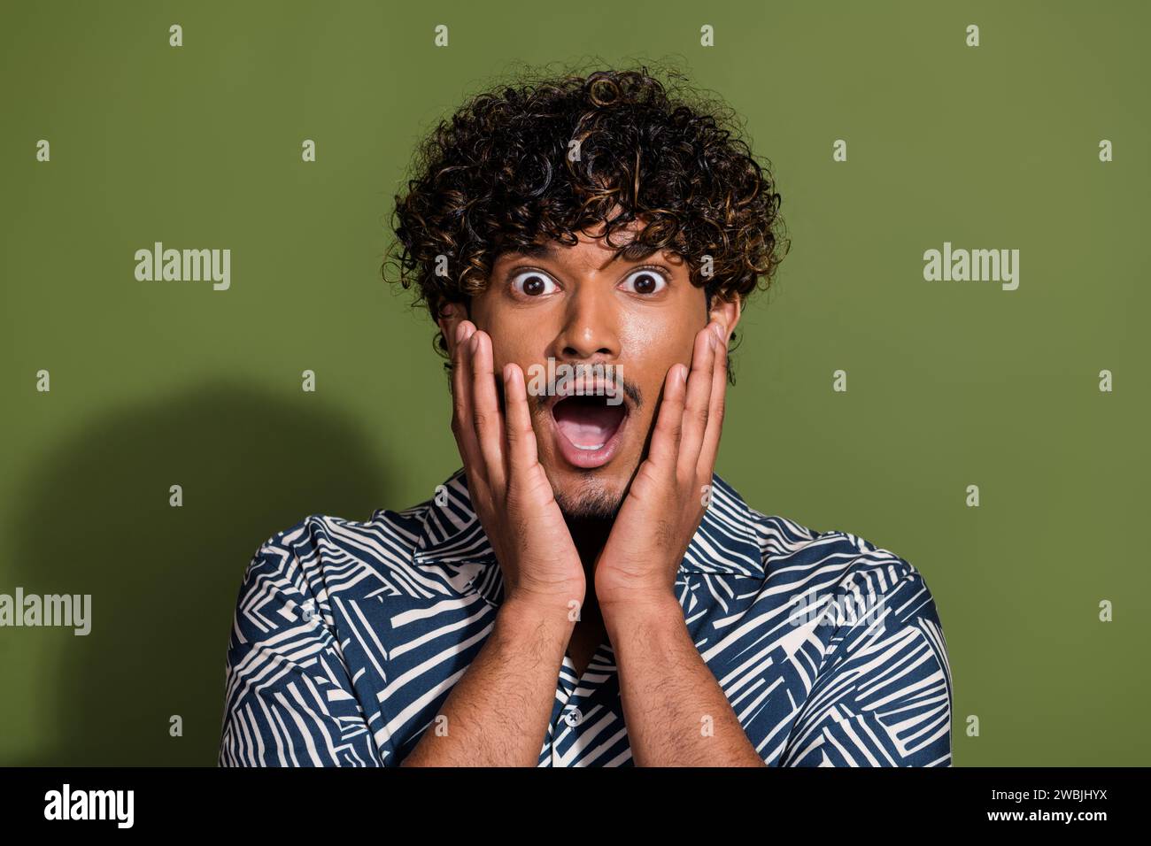 Portrait photo of young latin guy wear trendy shirt touch cheeks amazed ...