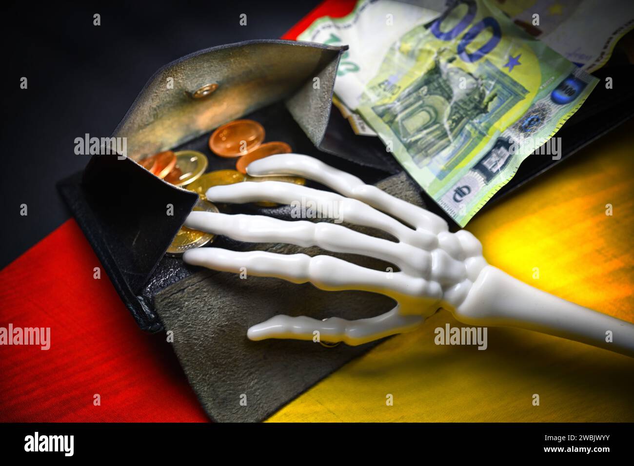Hand Skeleton On A German Flag Reaches Into A Wallet, Budget Crisis Stock Photo