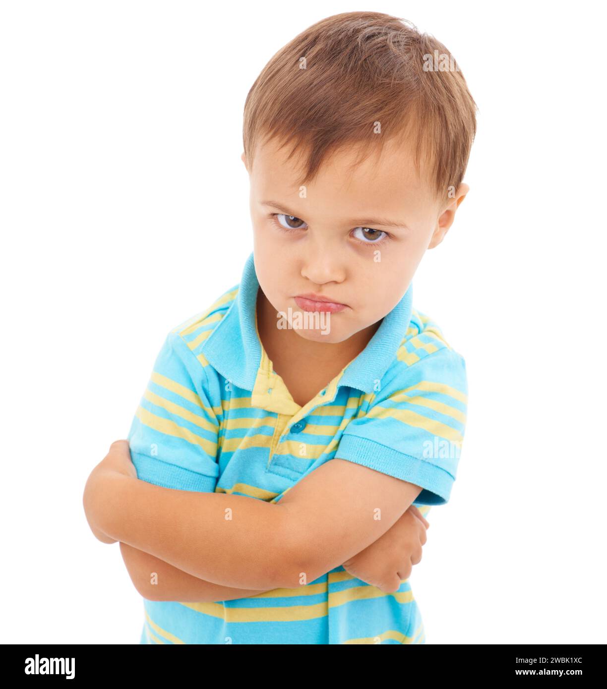 Boy, arms crossed and anger in studio portrait with mental health, anxiety and stress by white