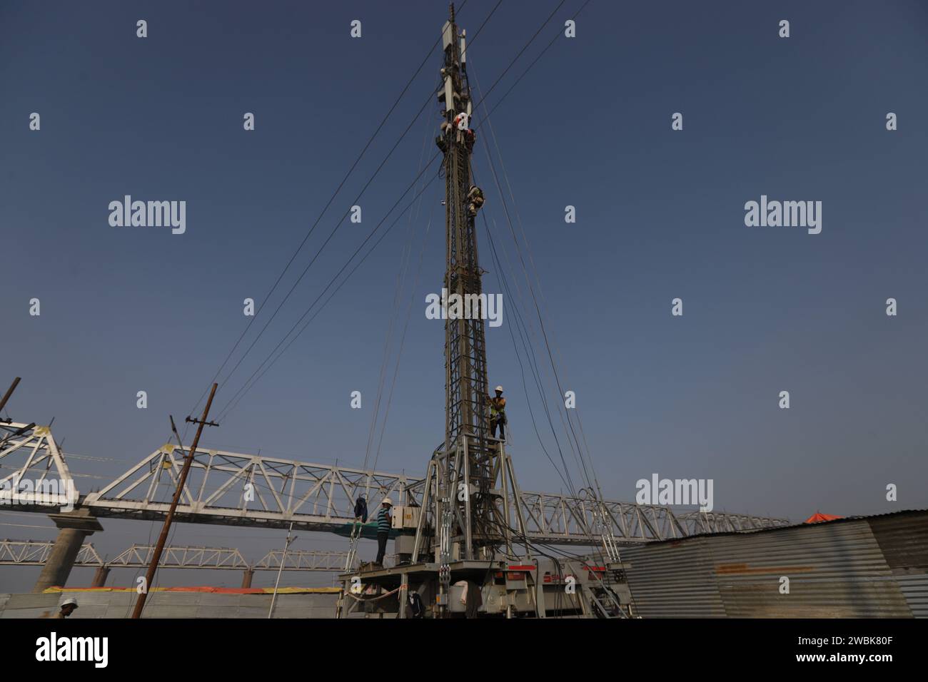 Prayagraj, India. 11 January 2024, Indian labourers install temporary mobile phone tower  at the banak of river Ganges during the prepraion for the upcoming one month long Magh Mela 2024 , in Prayagraj, India.  Credit: Anil Shakya/Alamy Live News Stock Photo