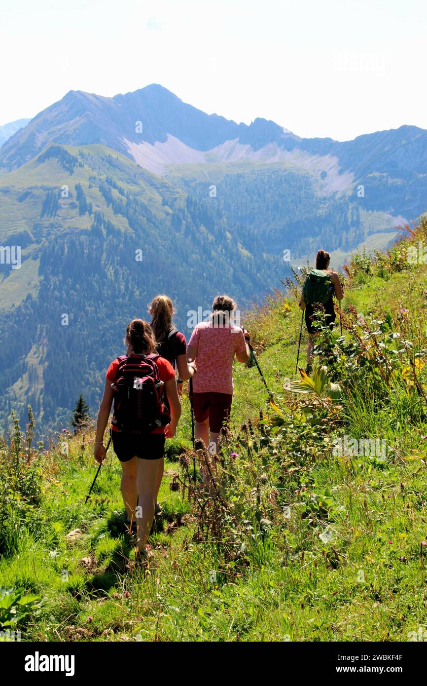 Hiking group of 4 women, coming from Gröbner Hals, near the Tiefenbachalm in Bächental, in the background you can see the Montscheinspitze in the midd Stock Photo