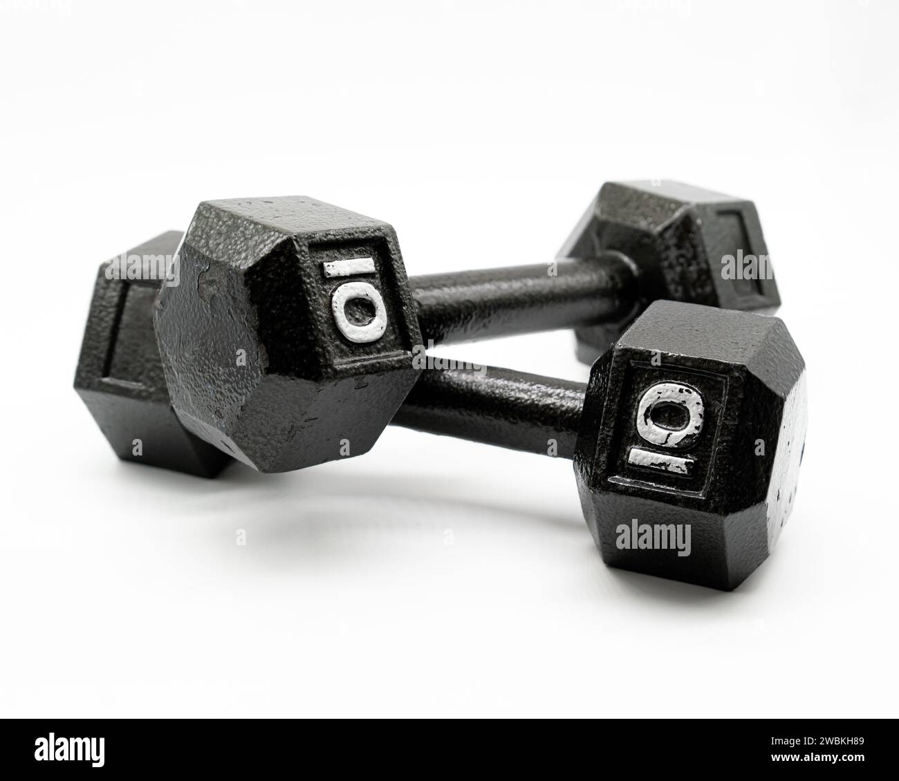 Two black steel ten pound dumbbell weights on a solid white background Stock Photo Alamy