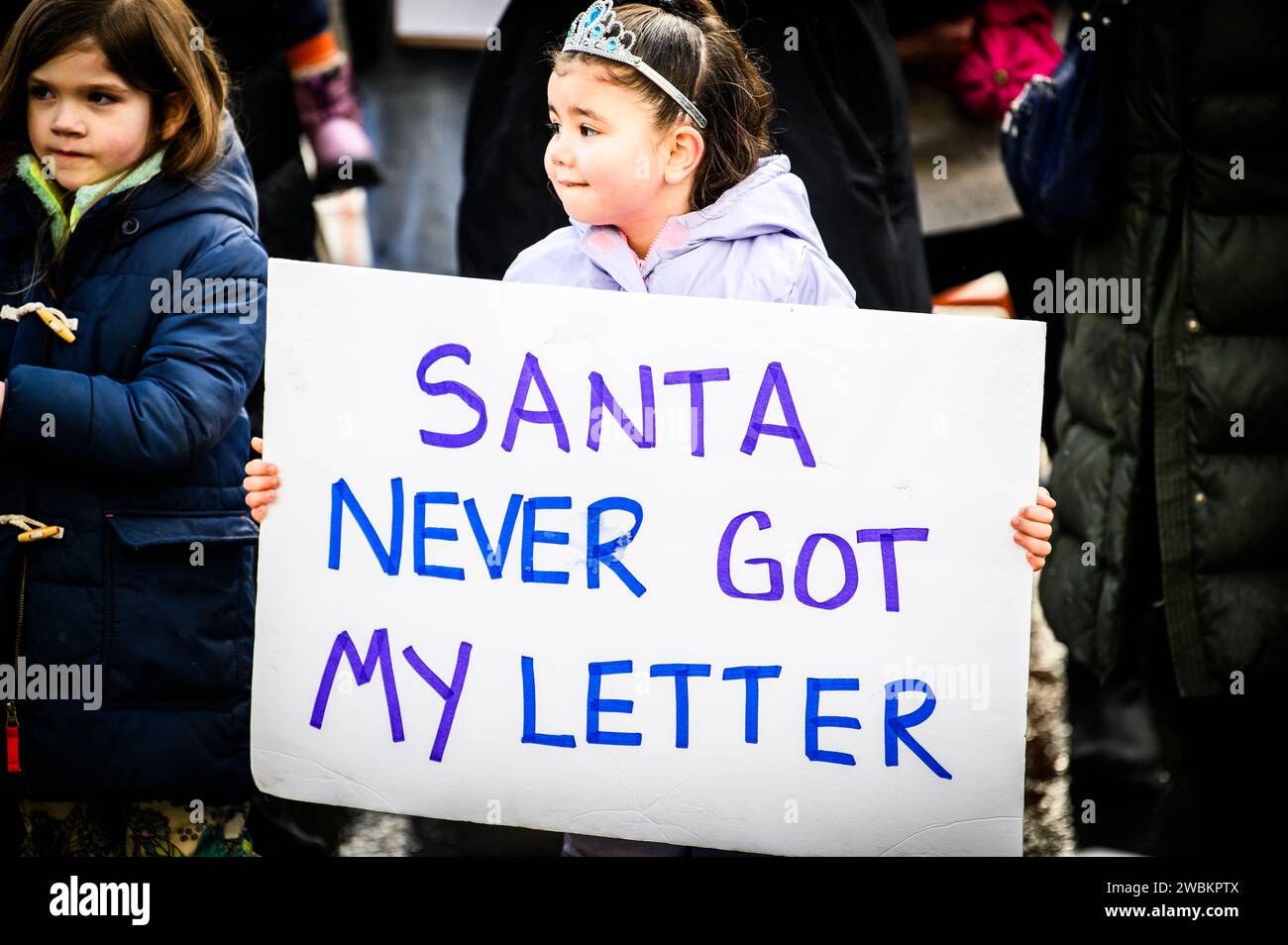 Child holds a sign complaining about lack of post office services in front of the Montpelier, VT, USA post office, closed due to flooding. Stock Photo