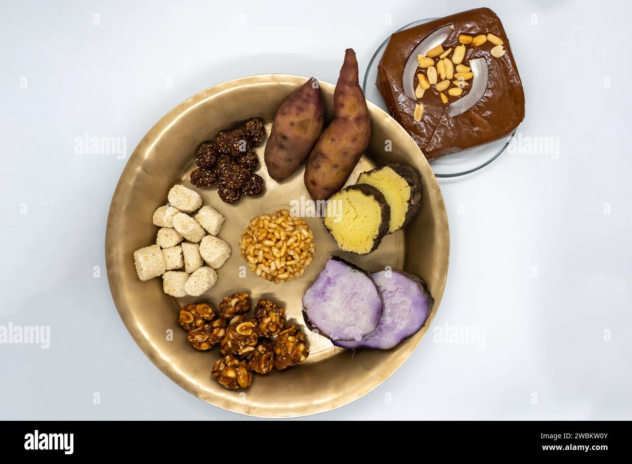 Maghe Sankranti Makar Festival Celebration Food Plate of Muri Ladoo, Sesame Ladoo, Yam, Sweet Potato, Jaggery, Peanuts Ladoo Ghee in India and Nepal Stock Photo