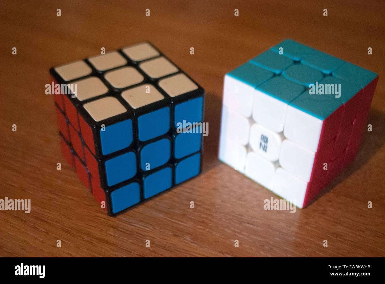 Two rubik's cubes on a desk showing red white and blue sides Stock Photo