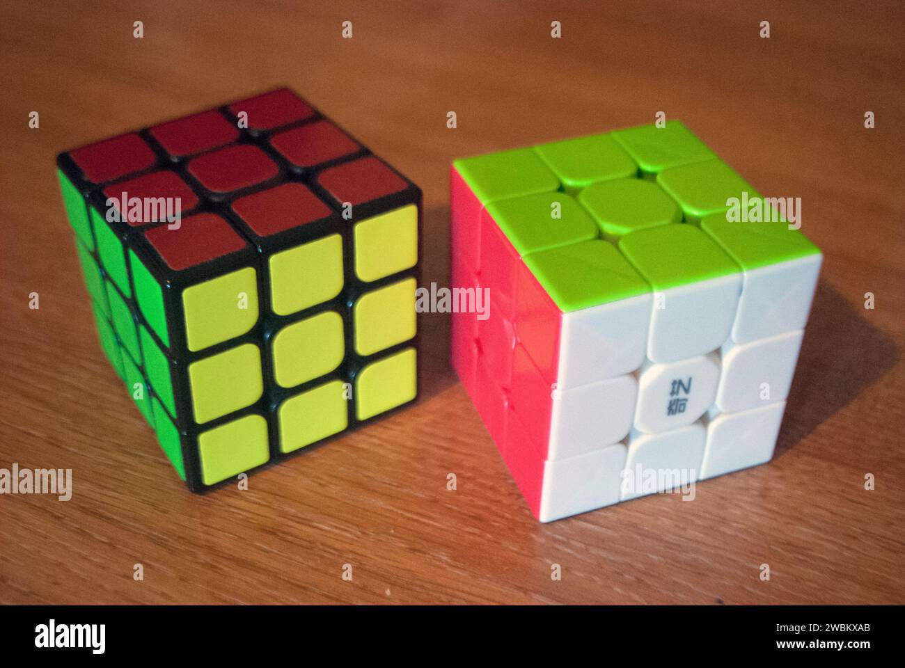 Two rubik's cubes on a desk Stock Photo