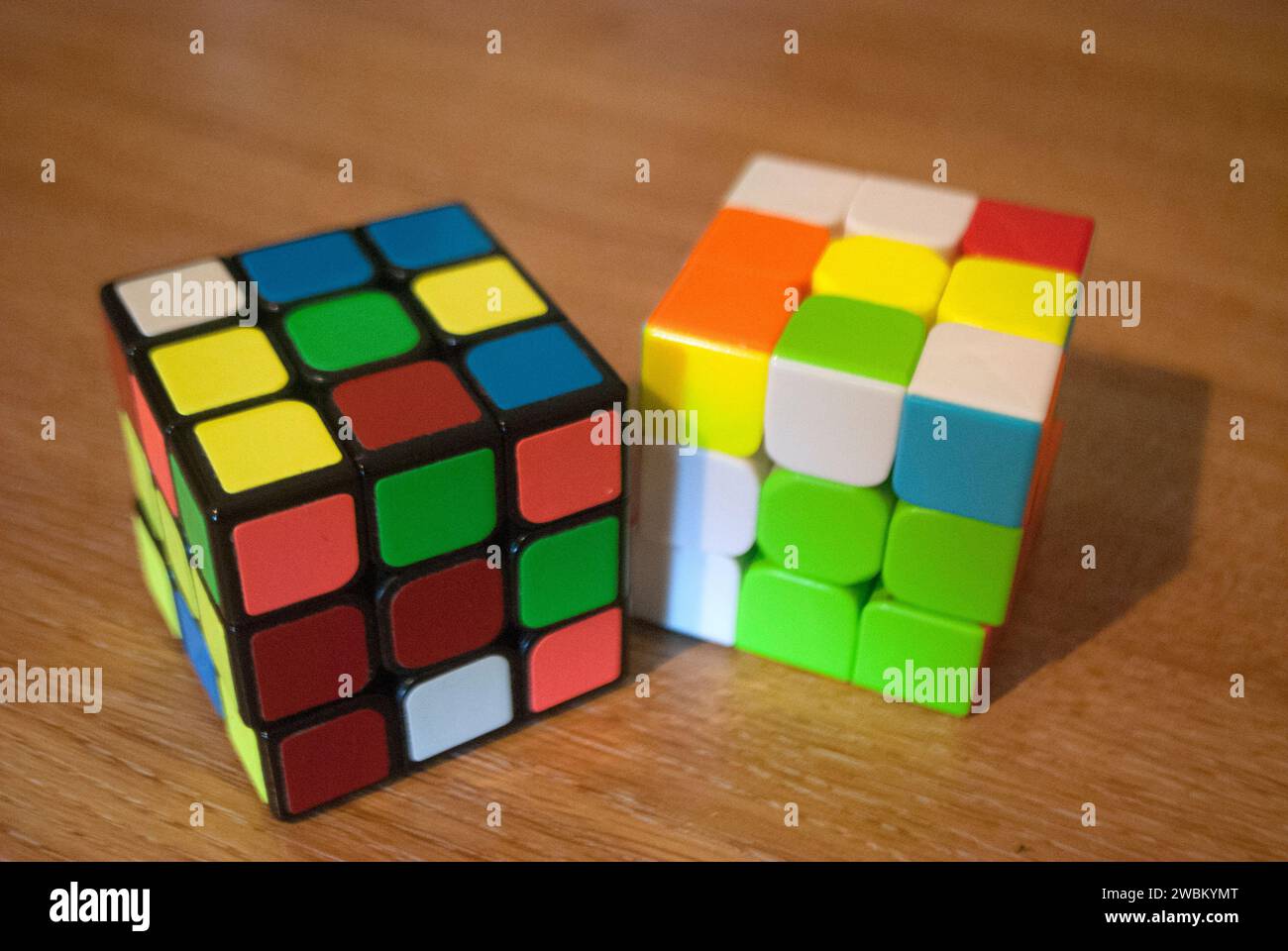 Two scrambled rubik's cubes on a desk Stock Photo Alamy