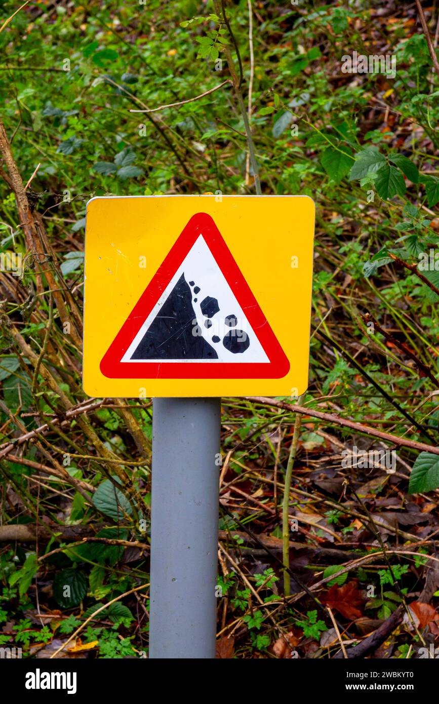 Warning sign with red triangle to indicate danger of falling rocks in a