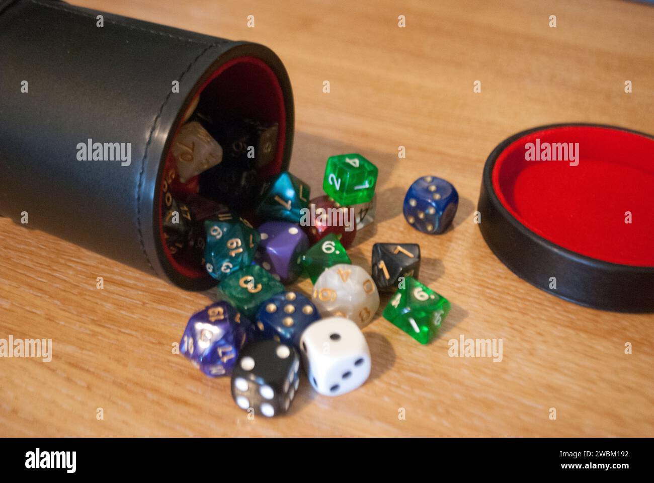 Dice spilling from black dice cup Stock Photo