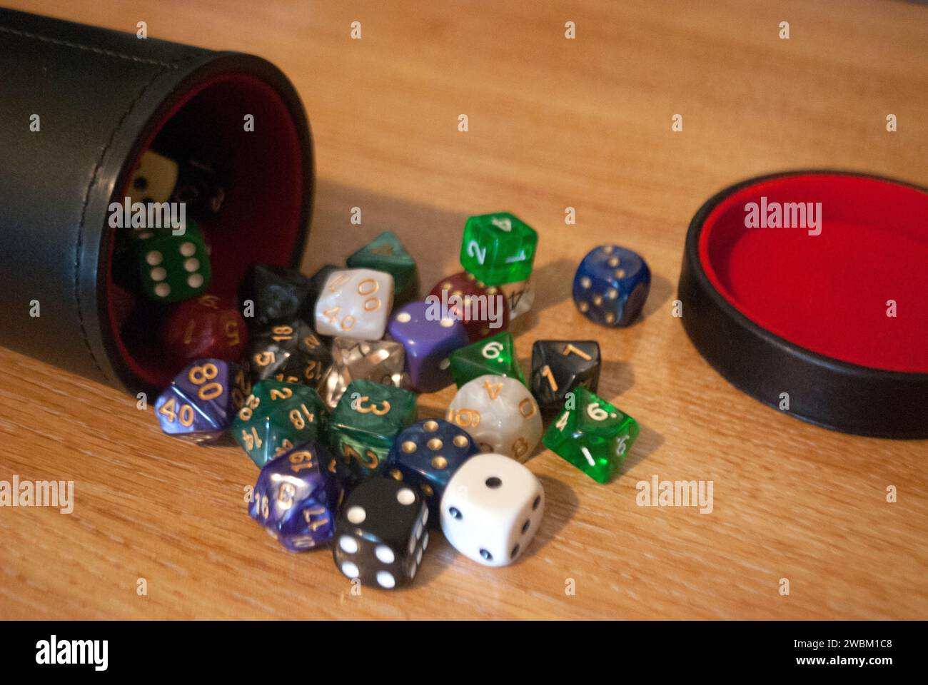 Dice spilling from black dice cup Stock Photo