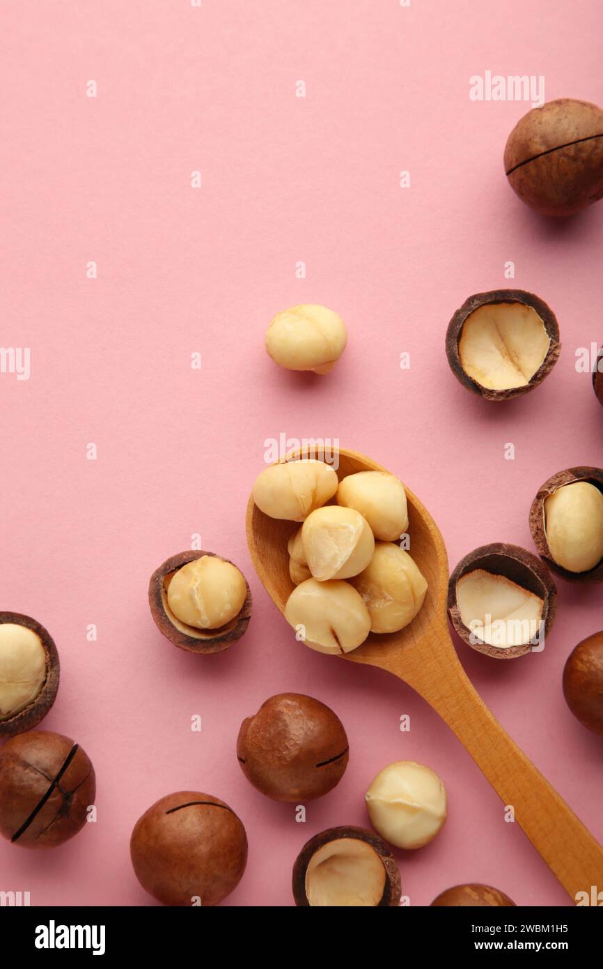 Macadamia in wooden spoon on pink background. Favorite for snack and very delicious.Have a lot of unsaturated fatty acid. Healthy food concept. Top vi Stock Photo
