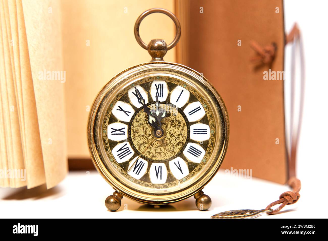 an old golden analog alarm clock with mechanical movement isolated on a ...
