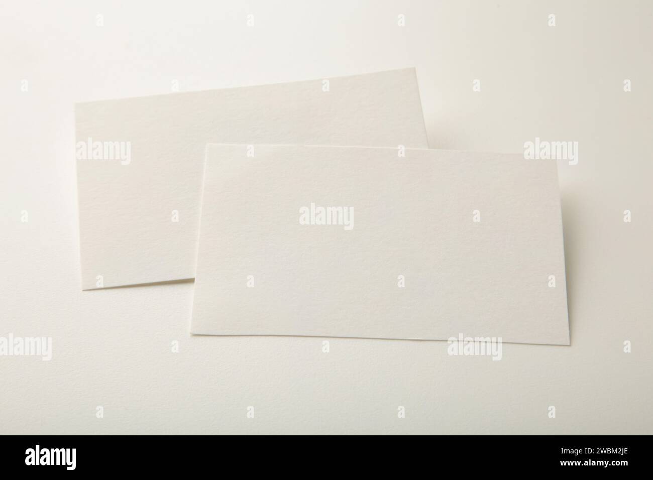 Blank white business cards on white paper background. Mockup for branding identity. Template for graphic designers portfolios. Stock Photo