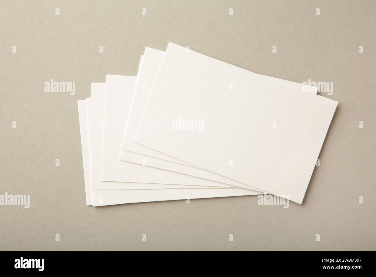 Blank white business cards on grey paper background. Mockup for branding identity. Template for graphic designers portfolios. Stock Photo