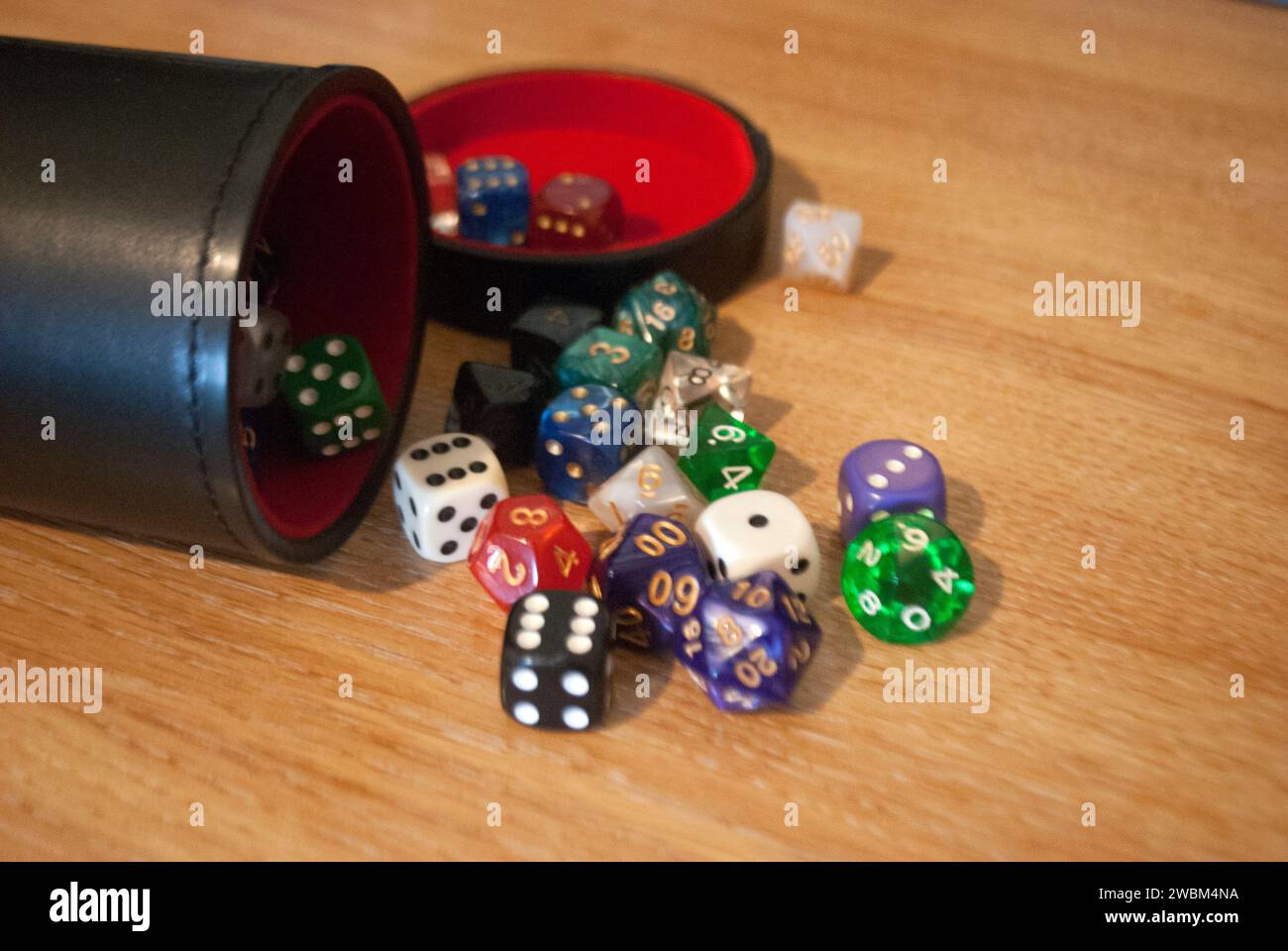 Dice spilling from black dice cup Stock Photo