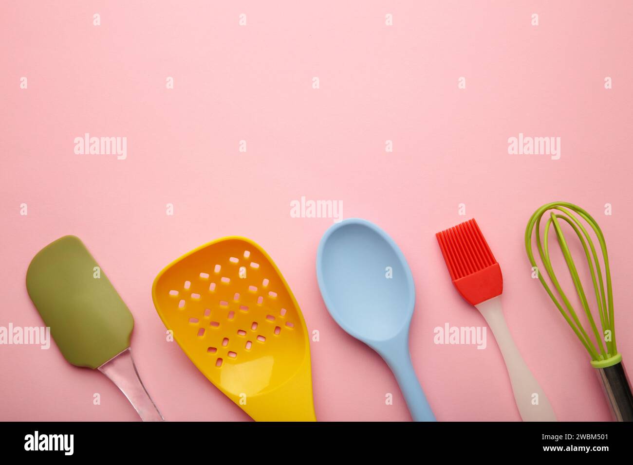 different kitchenware on a pink background top view. Cooking appliances ...