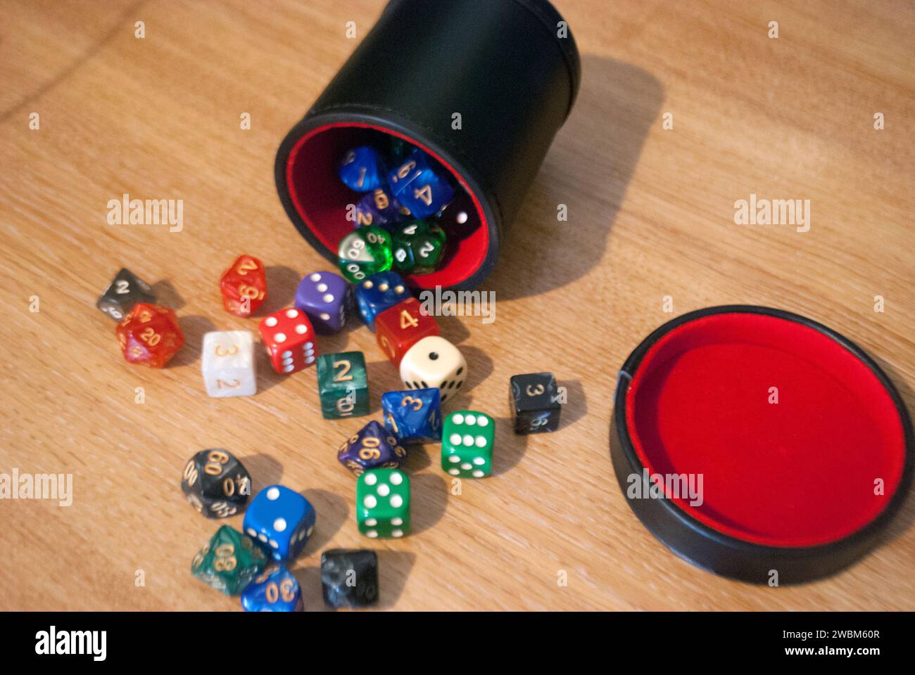 Dice spilling from black dice cup Stock Photo
