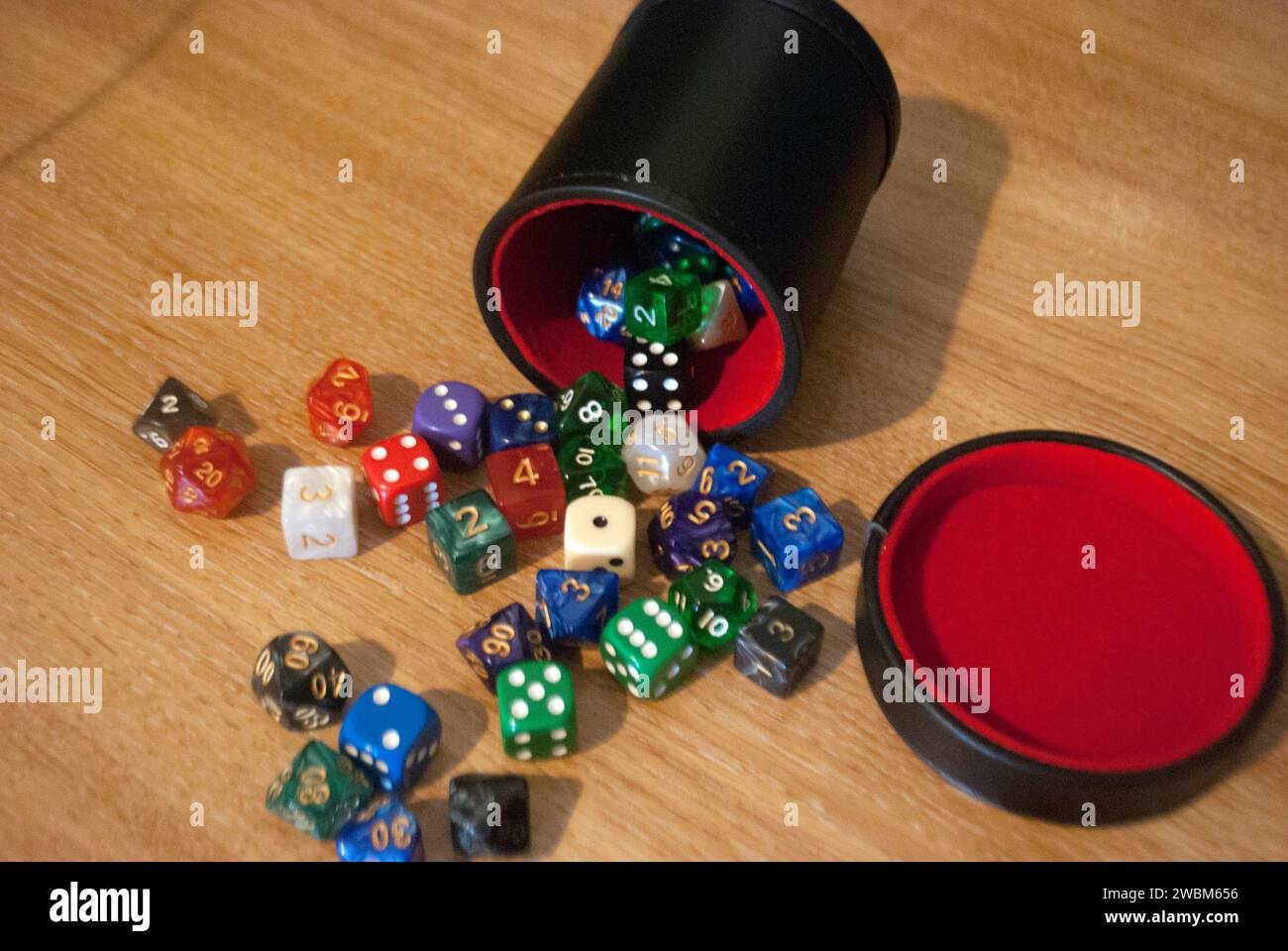 Dice spilling from black dice cup Stock Photo