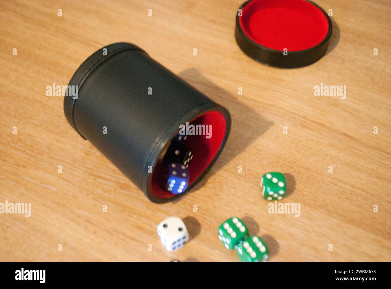 Dice spilling from black dice cup Stock Photo